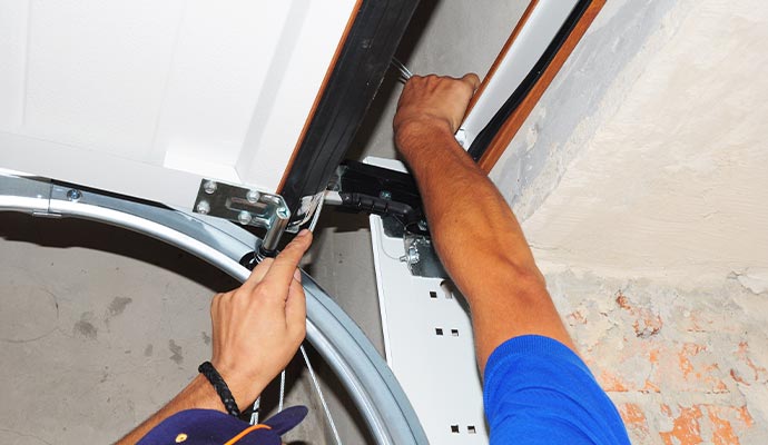 A technician installing a new garage door cable
