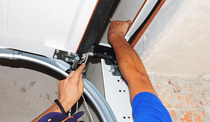 A technician repairing a garage door track