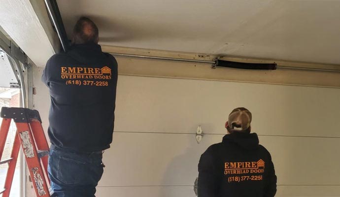 Couple of technician repairing garage door