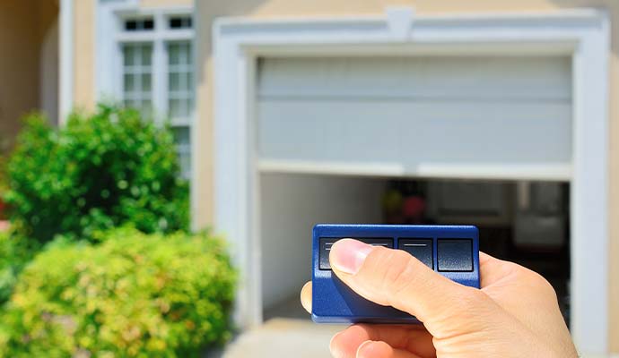 Person operating an automatic garage door with a remote control