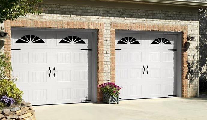Two side-by-side white carriage-style garage doors