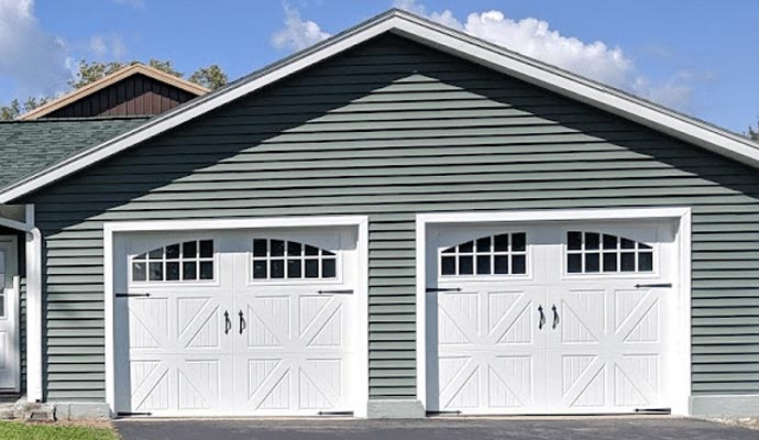 Two side-by-side white carriage-style garage doors