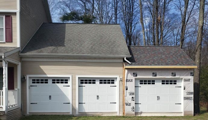 Three white garage doors with windows