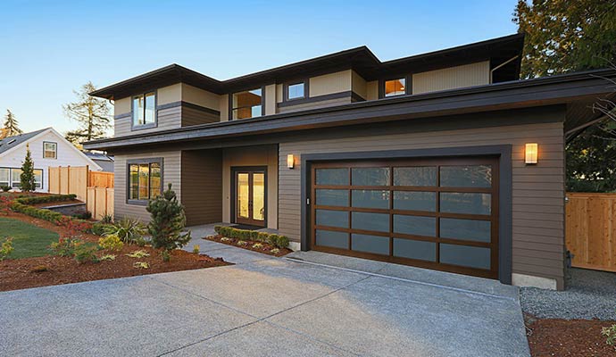 Modern two-story home with a contemporary Haas garage door featuring frosted glass panels