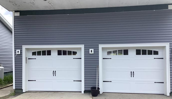 New arched-window carriage-style garage doors with black decorative hinges