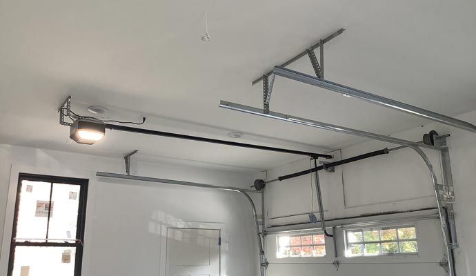 A newly installed overhead garage door system with professional tracks and belt-drive opener