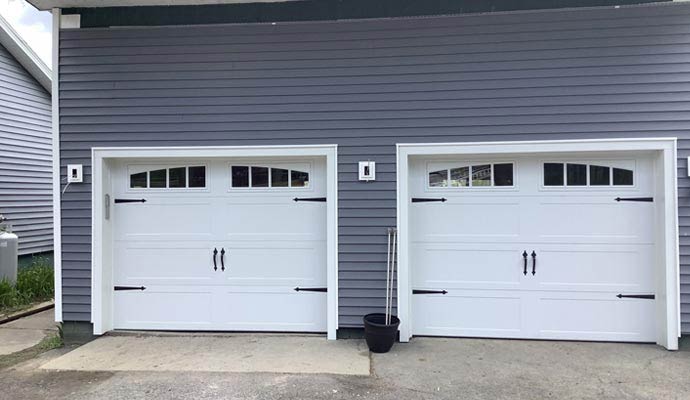 Two residential white carriage house garage doors